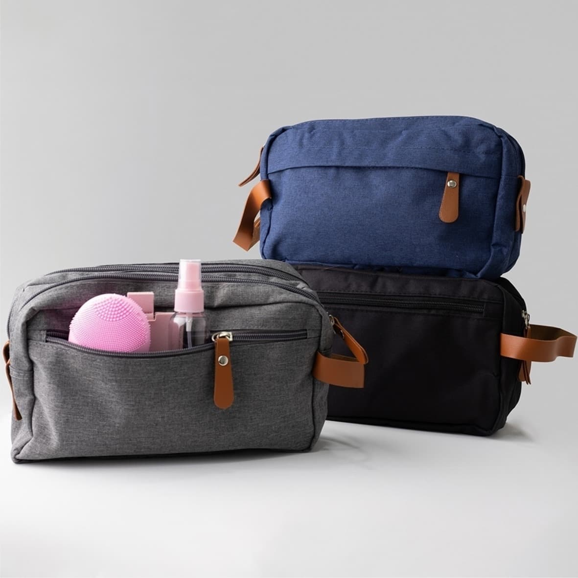 Nécessaire de viagem em tecido com alça de couro nas cores cinza, azul e preto